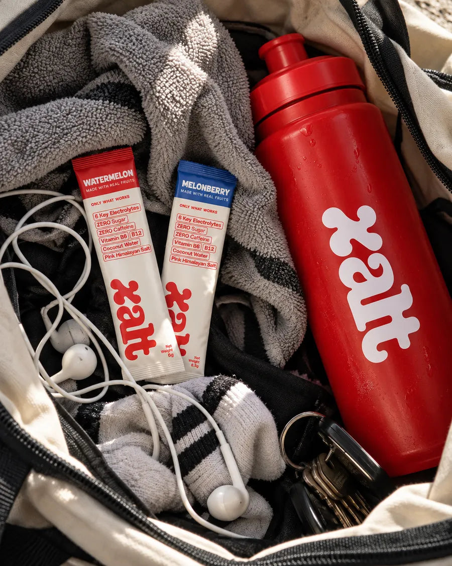 Two XALT sachets and a red XALT bottle in a gym bag