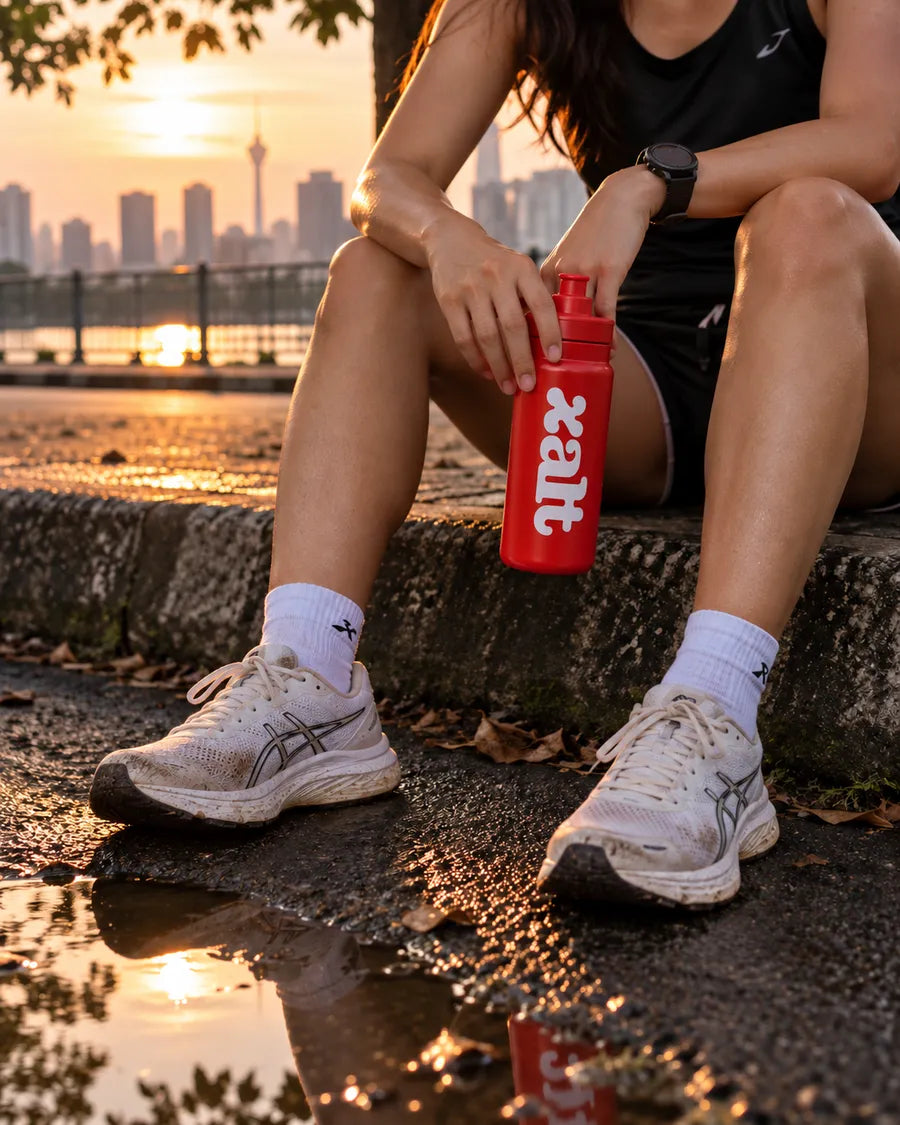 Resting after a run at sunset with a red XALT bottle